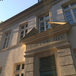 Das Bild zeigt die Fassade des Gebäudes, in dem das Stadtarchiv untergebracht ist. Es ist der Schriftzug STADTARCHIV darauf zu erkennen.